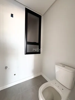 Foto de um banheiro com piso de cerâmica e louças brancas.