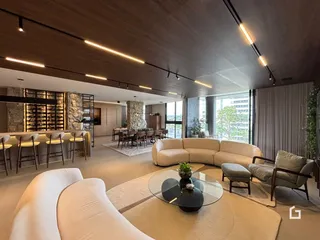 Sala de estar ampla com pé direito alto e iluminação moderna.