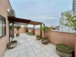 Varanda externa com piso de cerâmica e vasos de plantas.