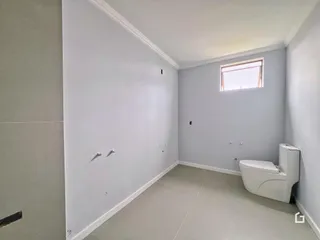 Hall de entrada com paredes brancas e piso claro.