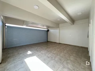Espaço interno amplo com porta de garagem de metal.