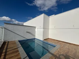 Vista externa de uma residência com piscina e fachada branca.
