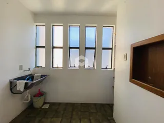 Vista de um corredor com janelas altas em uma residência.