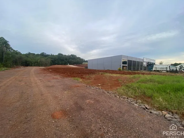 Vista externa de um edifício comercial em uma área de terreno aberto.