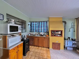 Foto de uma cozinha com armários de madeira e piso cerâmico.