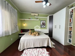 Quarto com paredes verdes e armários brancos.