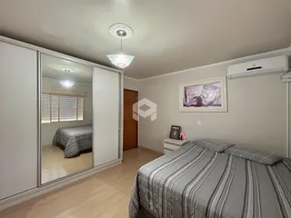 Quarto com cama e espelho refletindo o ambiente.