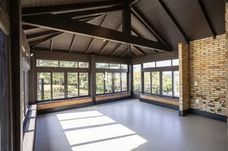 Sala ampla com grandes janelas que oferecem uma vista para a natureza.