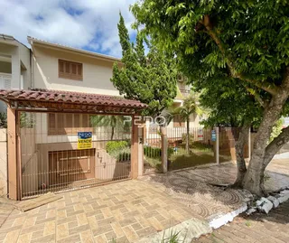 Fachada de uma residência em Lajeado, Brasil, com portão de ferro e jardim.
