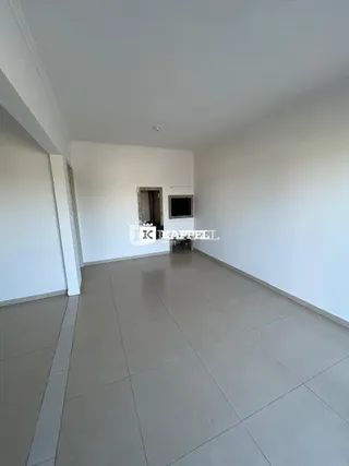 Vista de um corredor interno com paredes brancas e piso de cerâmica.