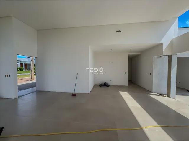 Hall da propriedade em Lajeado com paredes brancas e piso de concreto.