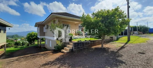 Fachada de uma residência em Lajeado, Brasil, com vegetação ao redor.