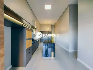 Hall de cozinha moderna com armários escuros e piso claro.