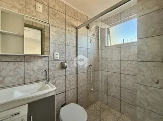 Foto de um banheiro com revestimento de cerâmica e box de vidro.