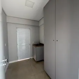 Hall de entrada com paredes brancas e armário embutido.