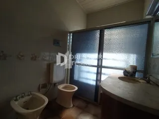 Foto do interior de um banheiro com pia e vaso sanitário.