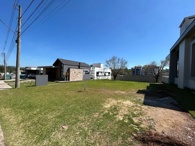 Vista externa de uma residência com um grande gramado e área verde.
