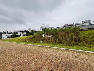 Vista da fachada da propriedade com área gramada e pavimentação.