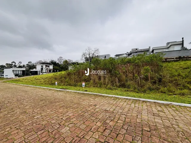 Vista da fachada da propriedade com área gramada e pavimentação.