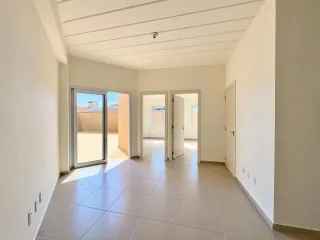 Corredor interno com piso de cerâmica clara e portas brancas.
