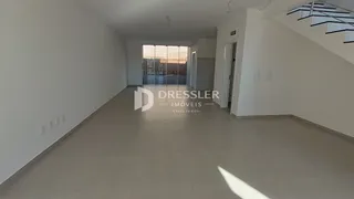 Hall de entrada com piso claro e paredes brancas.