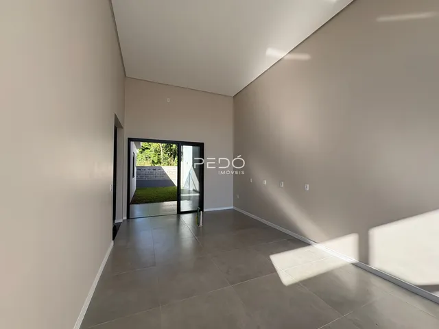 Interior de um ambiente com piso de cerâmica e porta de vidro.