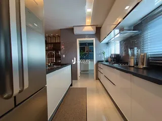Esta é uma vista da cozinha moderna com armários brancos e bancadas escuras.