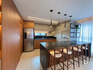 Foto de uma cozinha moderna com ilha e bancadas escuras.
