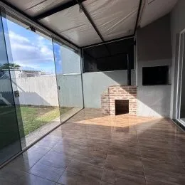 Sala de estar com portas de vidro que dão acesso ao quintal.