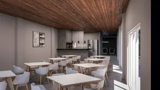 Uma sala de jantar longa com mesas e cadeiras brancas em um ambiente com teto de madeira.