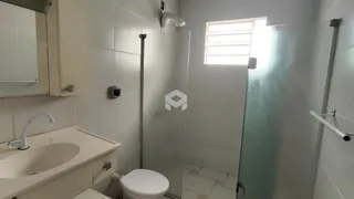 Foto de um banheiro com revestimento cerâmico branco.