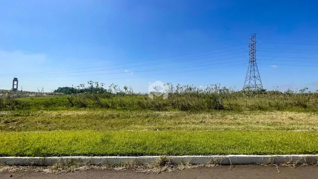 Paisagem de campo verde com uma cerca de concreto no primeiro plano.