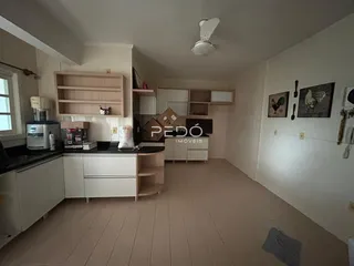 Imagem de uma cozinha com armários e piso de cerâmica em um imóvel no Brasil.