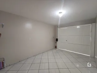Interior de um cômodo com piso de cerâmica e paredes brancas.