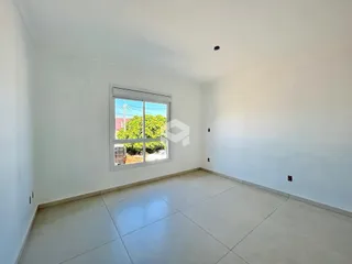 Vista interna de um cômodo com paredes brancas e piso de cerâmica.