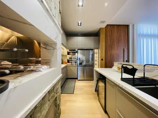 Cozinha moderna com armários e bancadas de mármore em um imóvel.