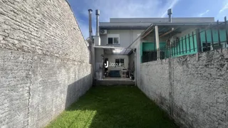 Vista externa da parede de concreto e gramado de uma residência em Lajeado.