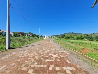 Uma estrada pavimentada com tijolos se estende por uma paisagem verde.