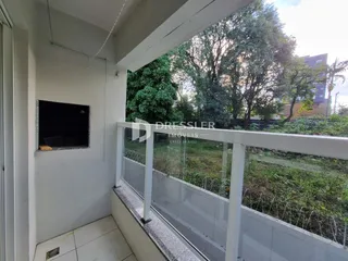 A foto mostra a vista de uma varanda com grade branca.