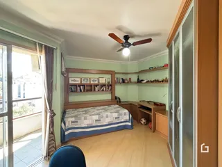 Quarto com cama e armários em um apartamento com vista para o exterior.