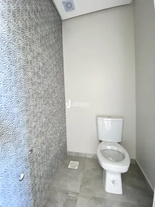 Foto de um banheiro com azulejos e vaso sanitário branco.