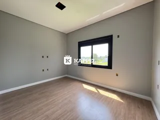 Sala de estar com piso de madeira e janela grande em um imóvel.