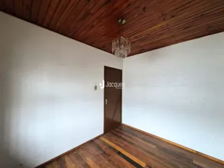 Interior de um cômodo com piso de madeira e teto de madeira.