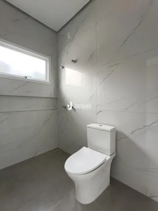Banheiro moderno com revestimento em mármore nas paredes.