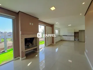 Sala de estar com piso claro e acesso a área externa através de portas de vidro.