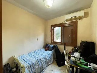 Quarto com cama e janela de madeira em um imóvel.