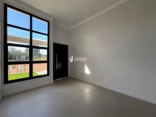 Uma sala com grande janela de caixilhos pretos.