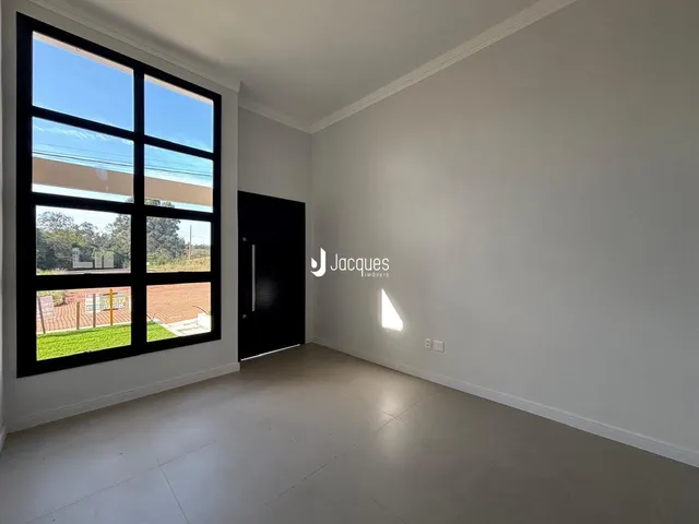 Uma sala com grande janela de caixilhos pretos.
