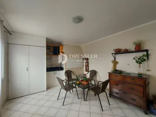 Ambiente interno de uma sala de jantar com piso de cerâmica e móveis de madeira.
