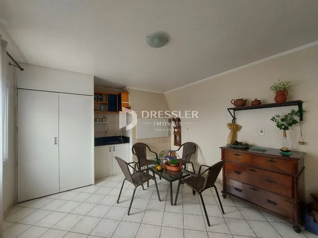 Ambiente interno de uma sala de jantar com piso de cerâmica e móveis de madeira.